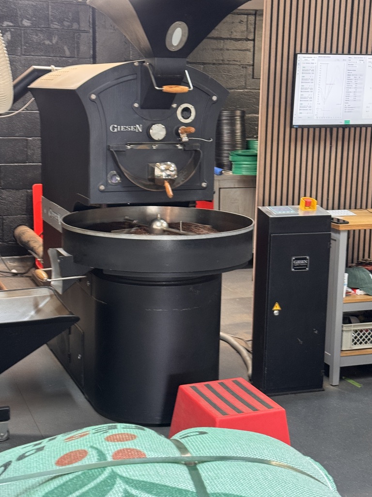 Roast profile monitor beside a Giesen coffee roaster during a specialty roast