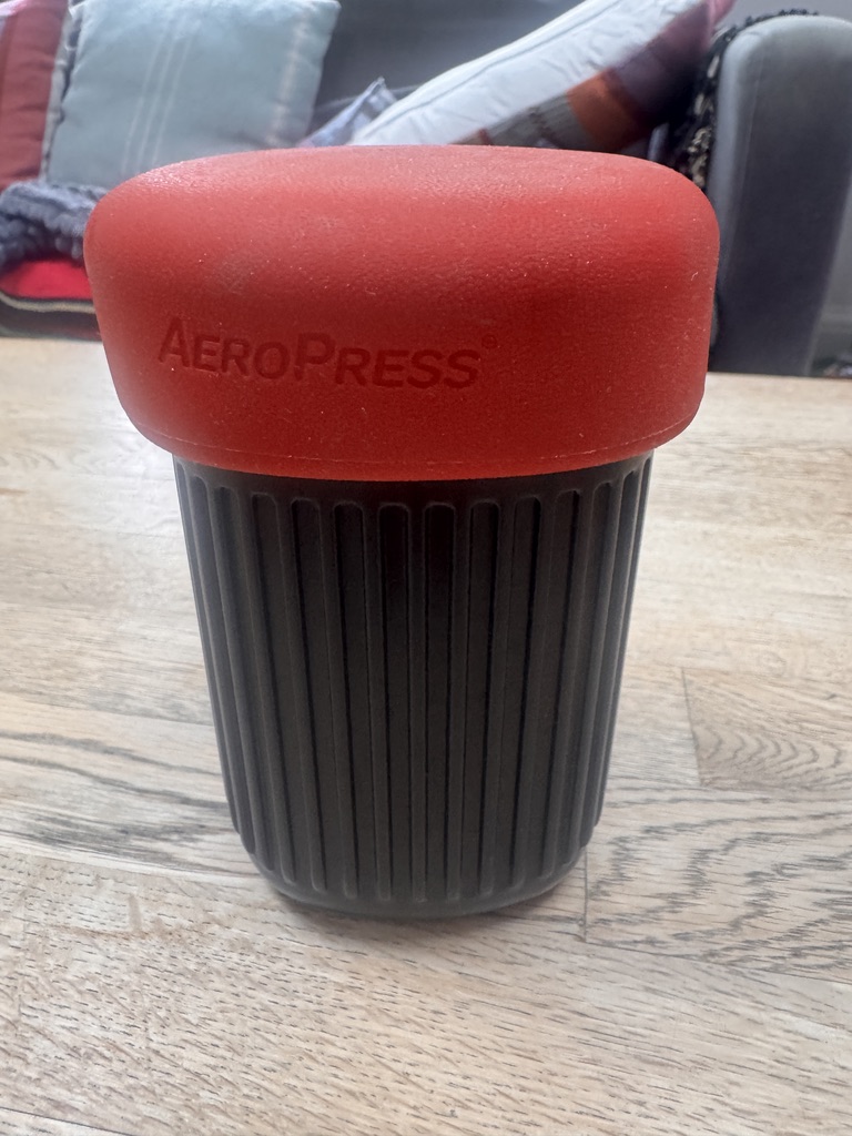 AeroPress Go packed into its black travel mug with the red silicone lid fitted in Ben Murrell’s original photograph